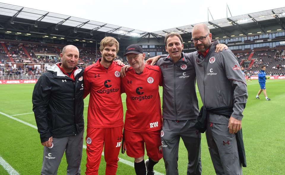 Beim Spiel gegen Stoke City feierte Ronald Wollmann (Mitte) sein 30-jähriges Jubiläum beim FC St. Pauli. Von den KollegInnen unserer medizinischen Abteilung wurde Wolli mit einer Torte überrascht.