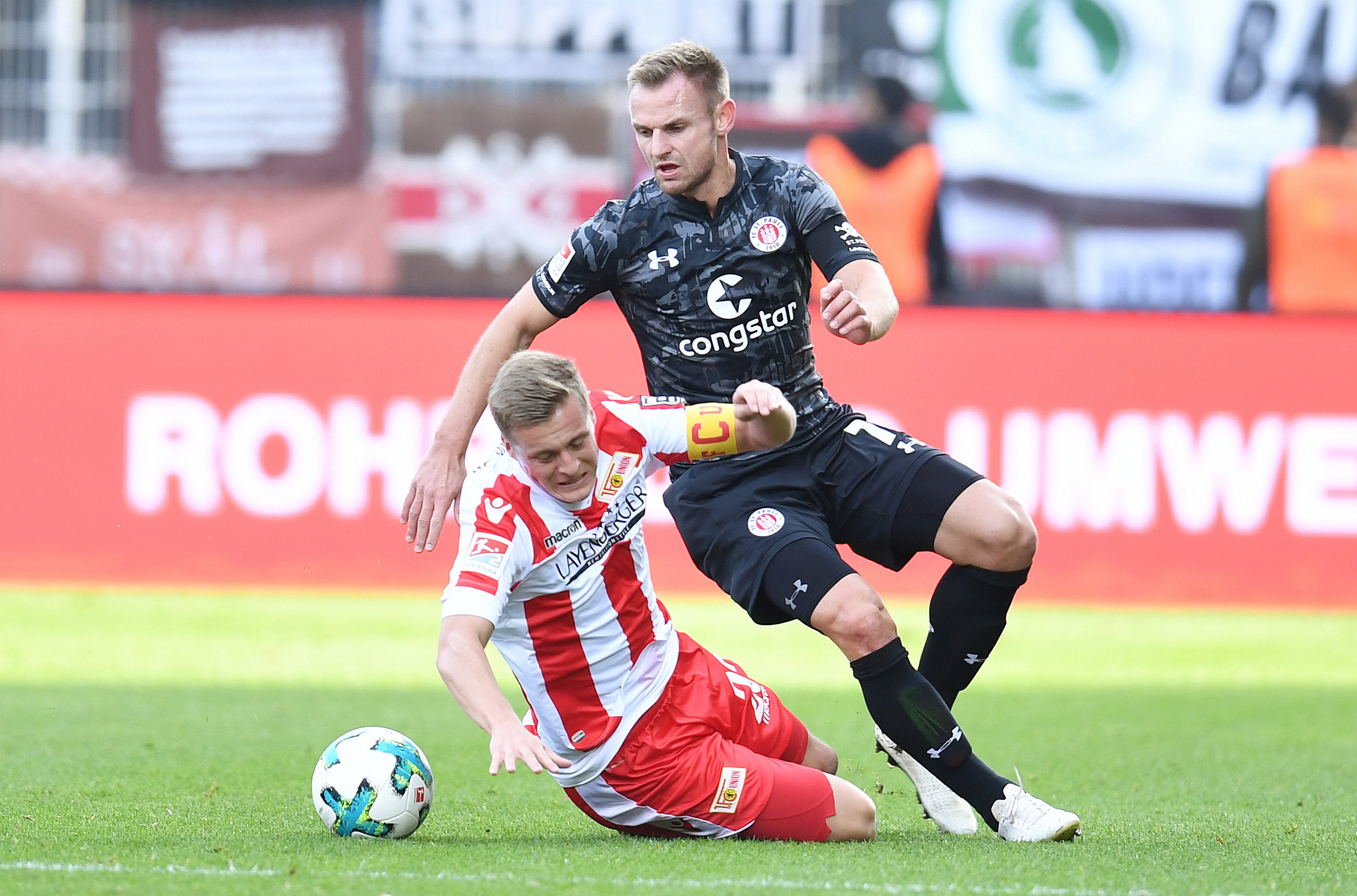 Captains Felix Kroos and Bernd Nehrig battle for the ball in a hard-fought contest.