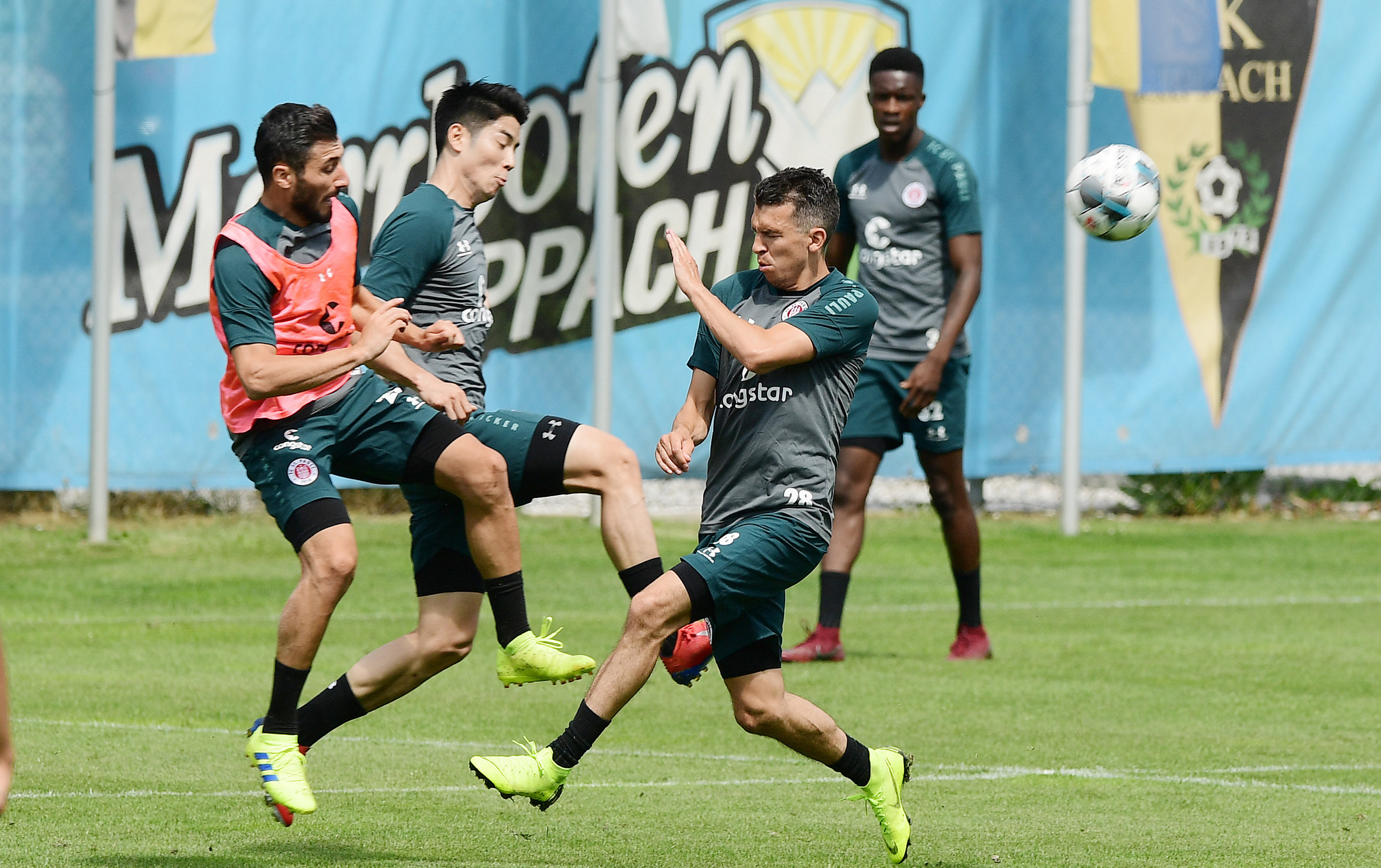 Flat out at the Austrian training camp - Cenk Sahin challenges for the ball with Yiyoung Park and Waldemar Sobota.