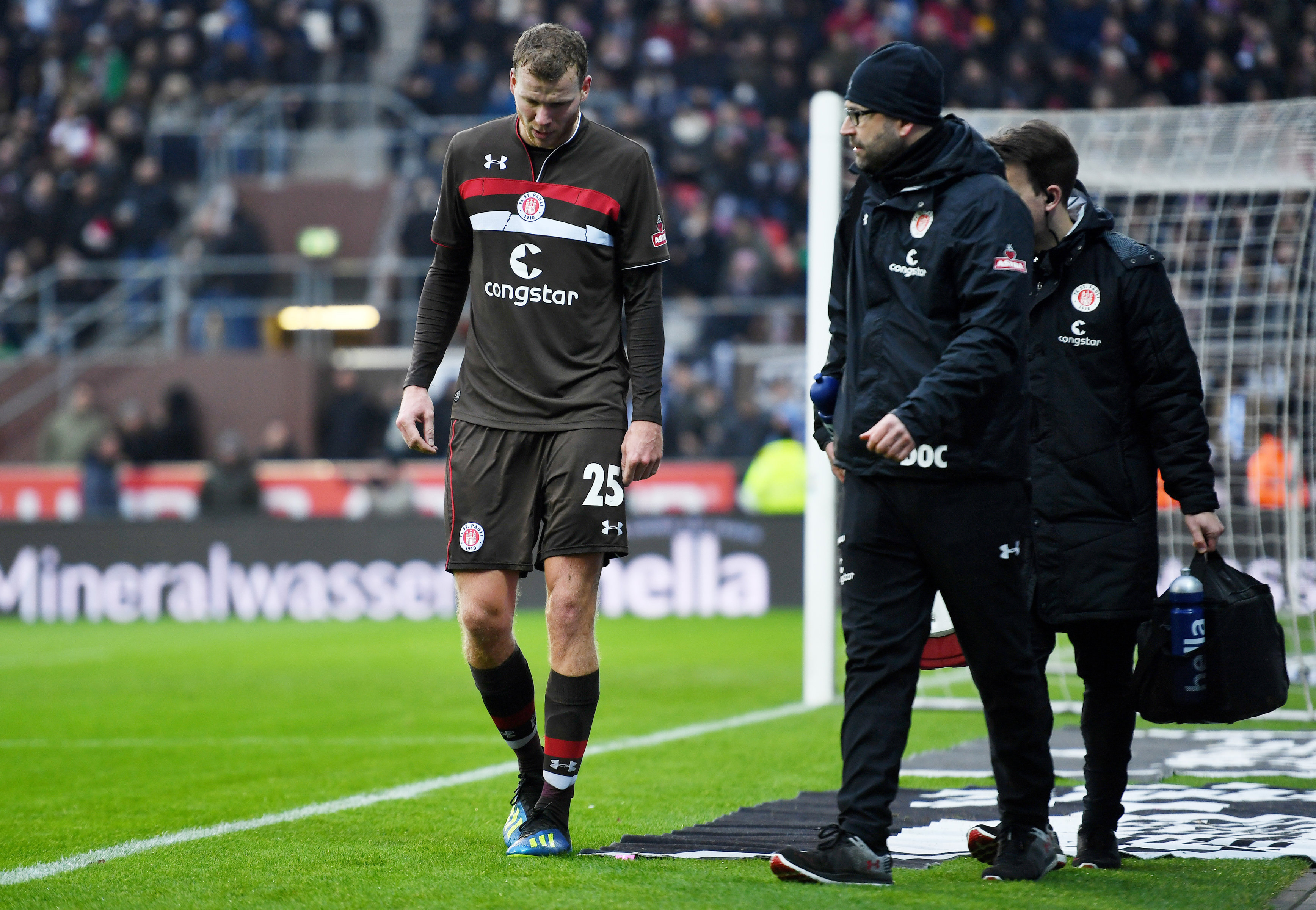 Henk Veerman makes his way off the pitch, accompanied by club doctor Sebastian Schneider and physiotherapist Mike Muretic.